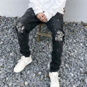 Raw-edge appliquéd cashew flower splattered straight ripped black jeans