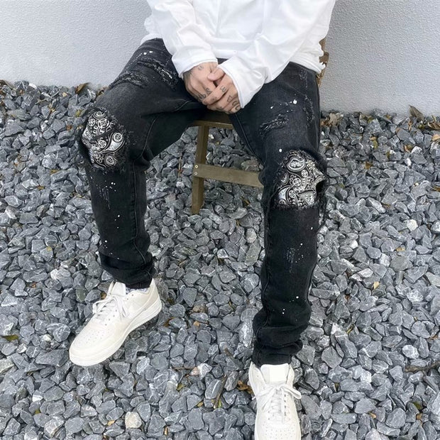 Raw-edge appliquéd cashew flower splattered straight ripped black jeans