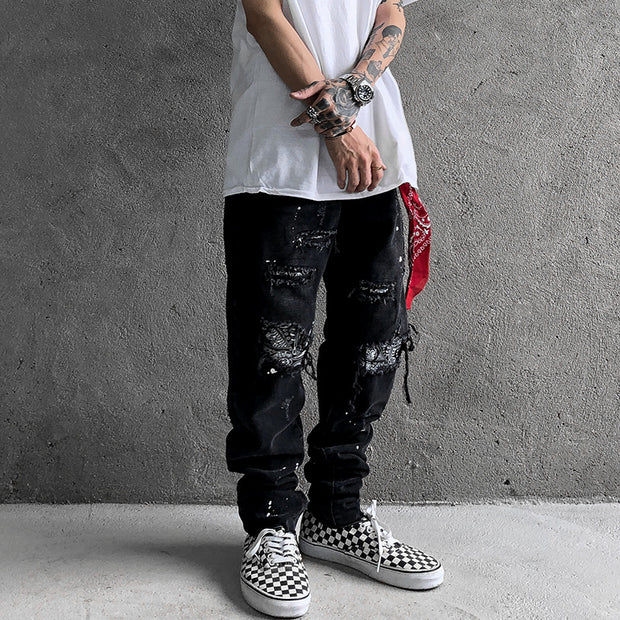 Raw-edge appliquéd cashew flower splattered straight ripped black jeans
