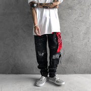 Raw-edge appliquéd cashew flower splattered straight ripped black jeans