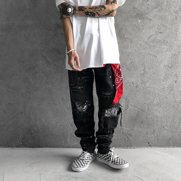 Raw-edge appliquéd cashew flower splattered straight ripped black jeans